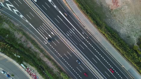 Aerial-view-of-a-road-intersection-and-a-multi-lane-highway-with-cars-driving