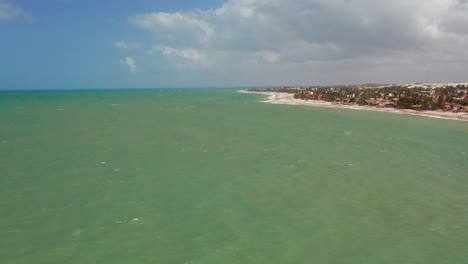 antena: cumbuco durante el día con gente haciendo kitesurf