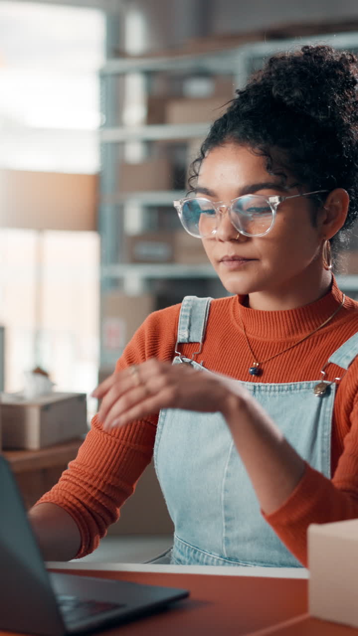 Young Woman Working on Laptop in Small Business Office