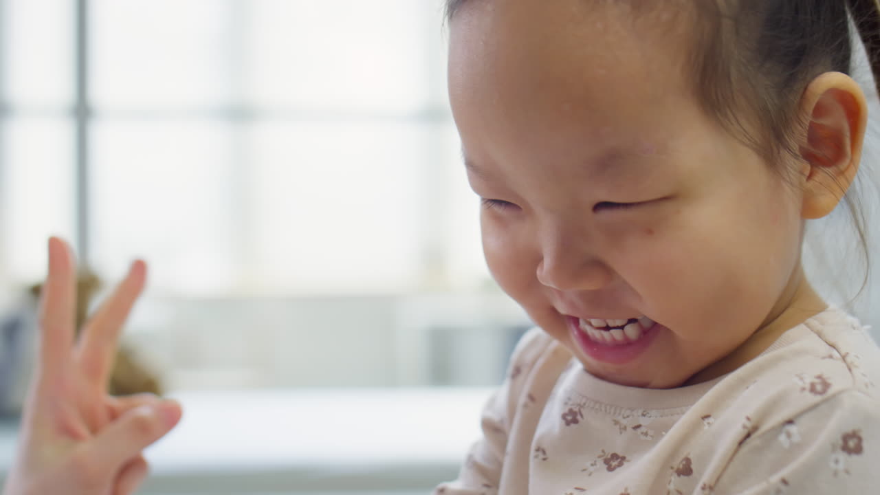 Joyous Asian Toddler Girl Playing with Female Pediatrician