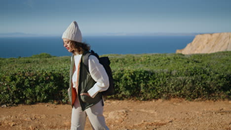 relaxed girl admiring landscape at ocean cliff. young tourist walking pathway