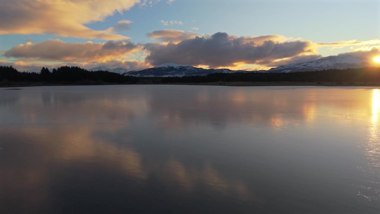 Esquel'deki Laguna La Zeta'nın kristal berraklığındaki suları, ayna gibi dağ yansımalarını yakalıyor. Hızlı sol takip havadan çekim. Esquel. Chubut, Arjantin.