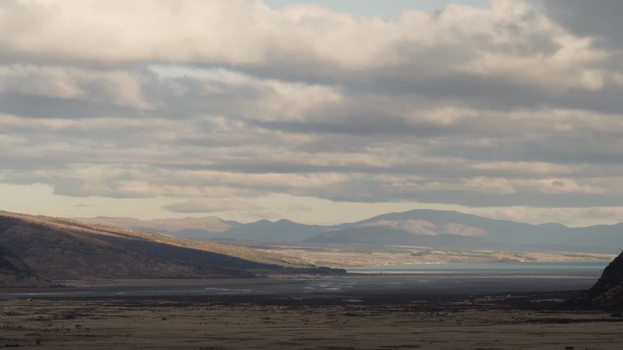 Paesaggio autunnale della Nuova Zelanda con montagne sotto la pioggia, con nuvole che si muovono velocemente tra le montagne.