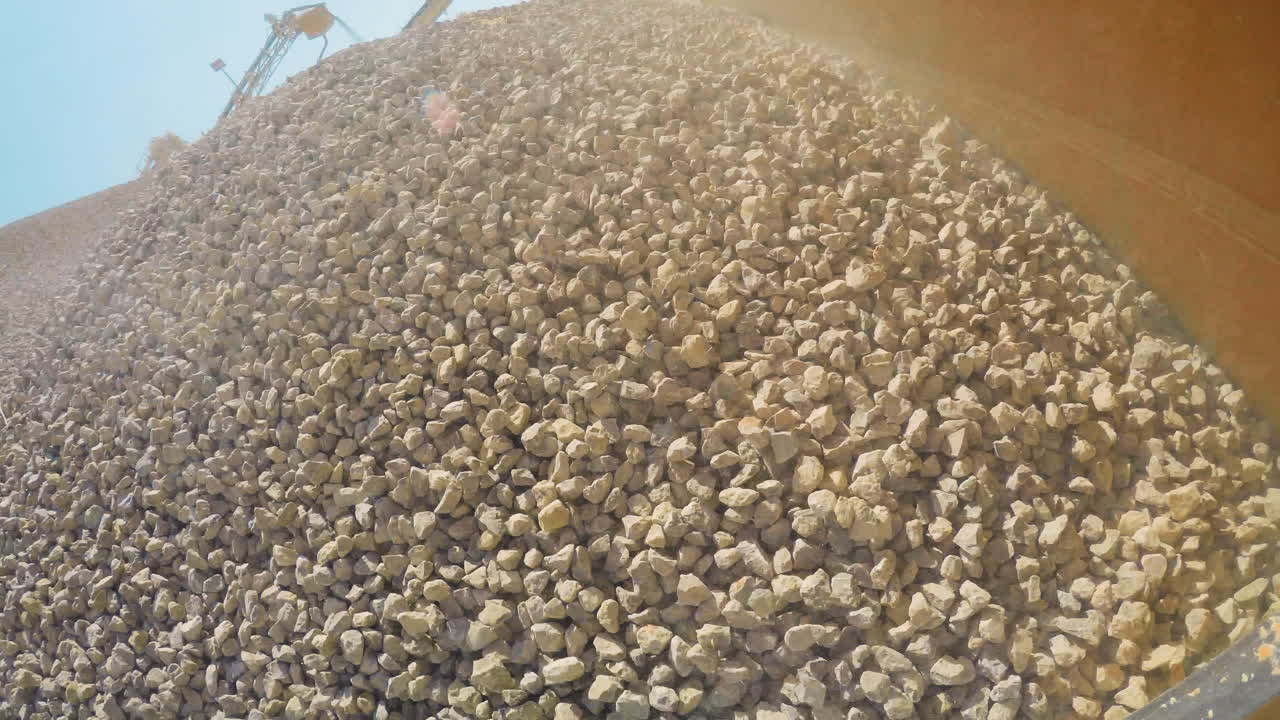 Industrial sand mining. Very Interesting Point of View. 4K Camera is Stuck on a working loader. Left side. Loading and dumping gravels into a truck, Industrial machinery at sand quarry, 4K footage.
