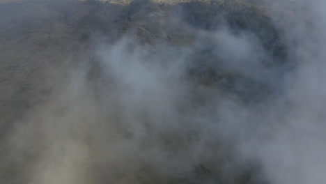 Drone-dolly-view-of-white-clouds-revealing-the-slopes-of-Haleakala-volcano-on-Maui,-Hawaii