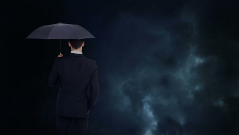 businessman looking at storm with umbrella