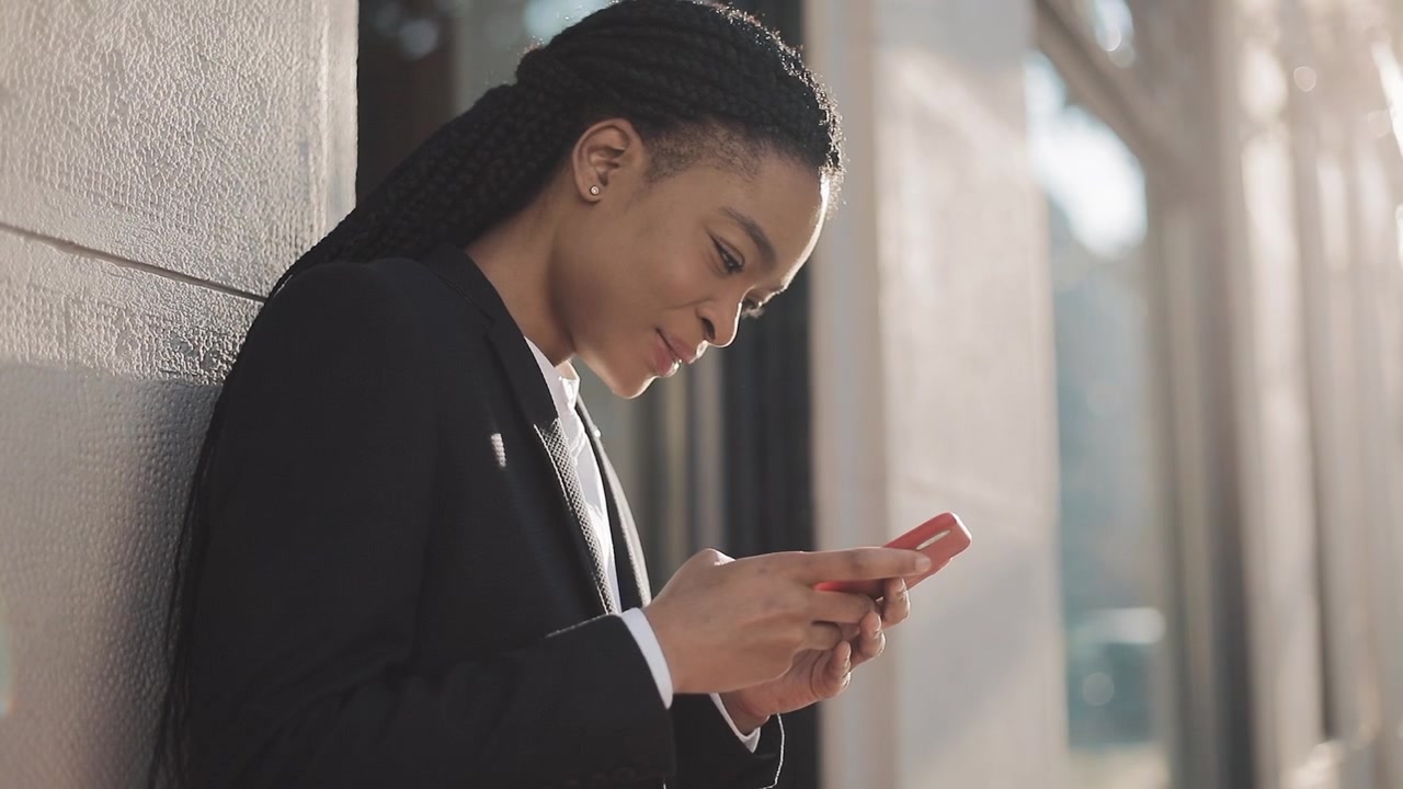 Giovane donna professionista che usa lo smartphone all'aperto