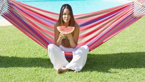 hungry woman biting into watermelon slice