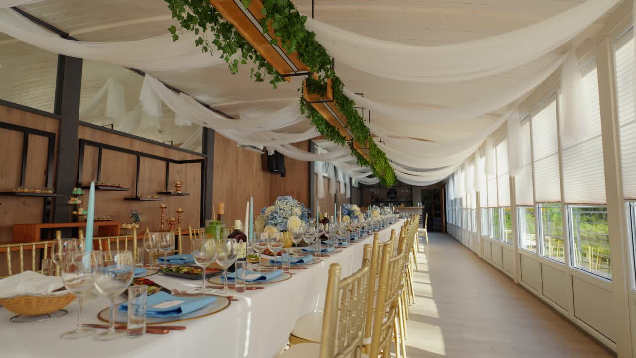tiro de mesa de comedor de lujo para una ocasión de boda en el área del restaurante cubierto con una vista al jardín en un día soleado