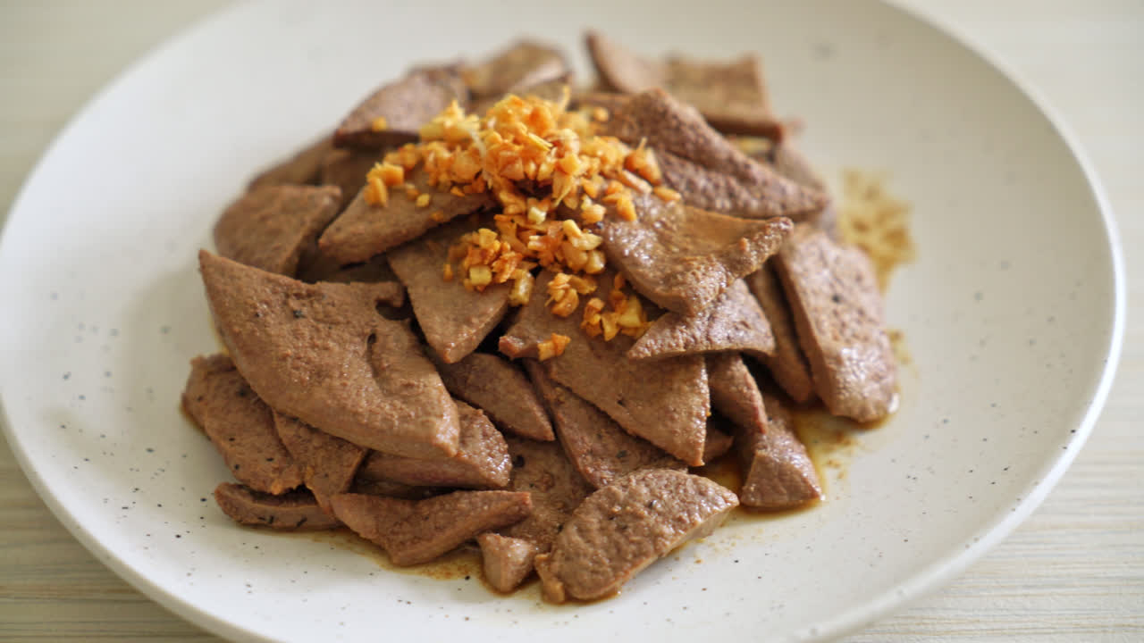 접시에 마늘을 곁들인 집에서 볶은 돼지 간