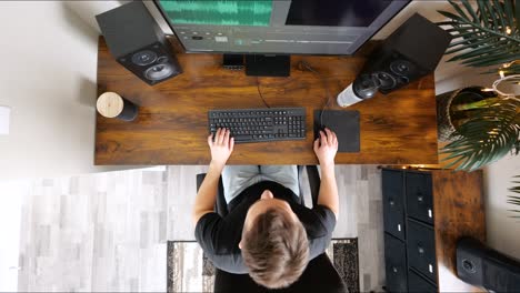 top down timelapse shot of white male working on a desktop home office computer