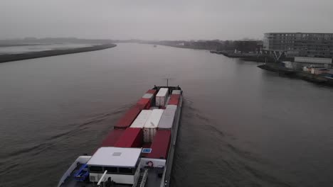 Frachtschiff-Mit-Intermodalen-Containern,-Die-An-Einem-Düsteren-Tag-Den-Fluss-Noord-überqueren