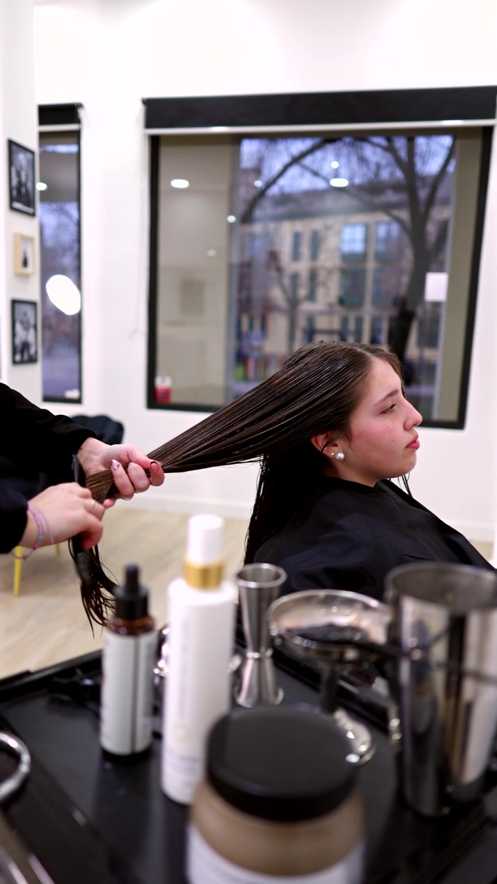 Cabeleireiro profissional penteando o cabelo molhado de um cliente em um salão