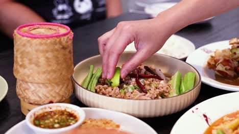 hand squeezing lime over traditional thai food