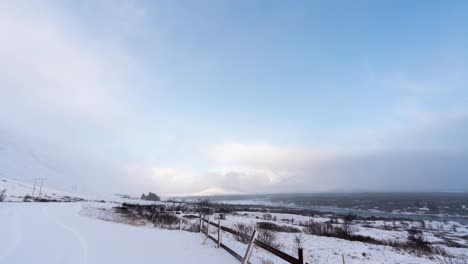 time lapse shot of stormy clouds flying over snowy iceland island in winter