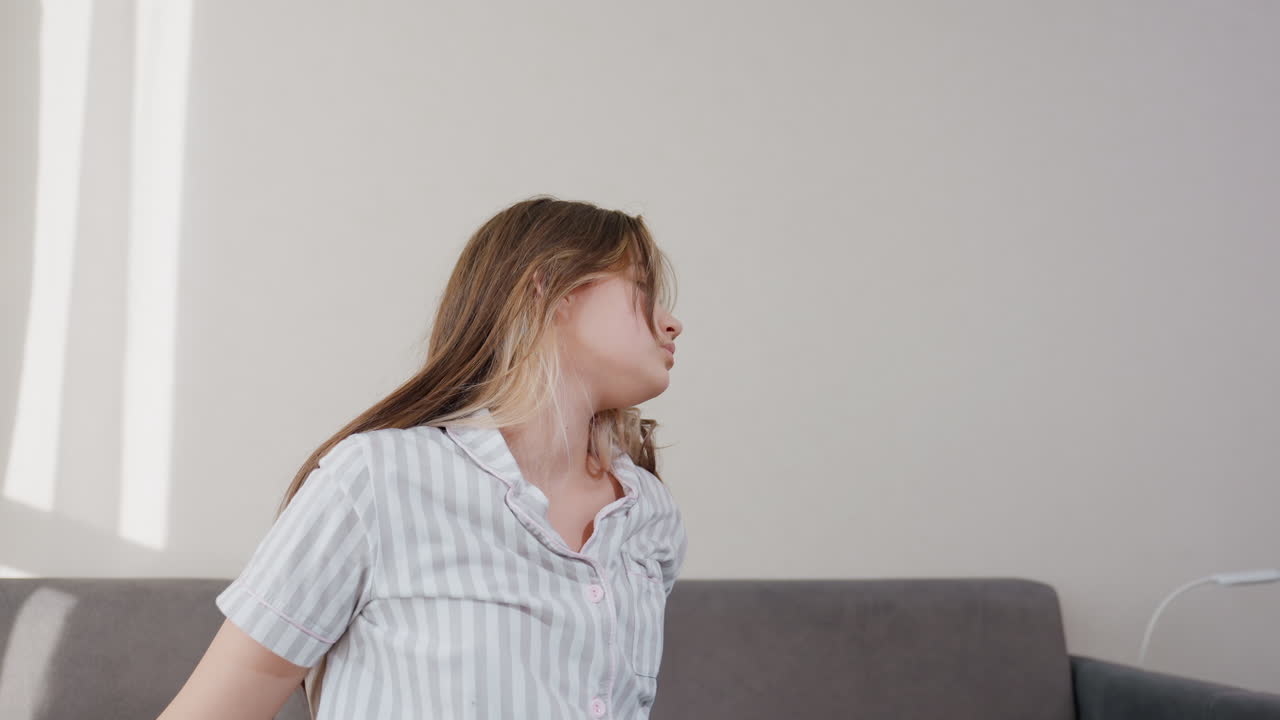 Calma vittoria catturata in posa delicata, giovane donna mostra quieta resilienza con movimenti leggeri, ragazza adolescente esprime pacifica sicurezza allungando le braccia in una scena illuminata dal sole su una coperta blu