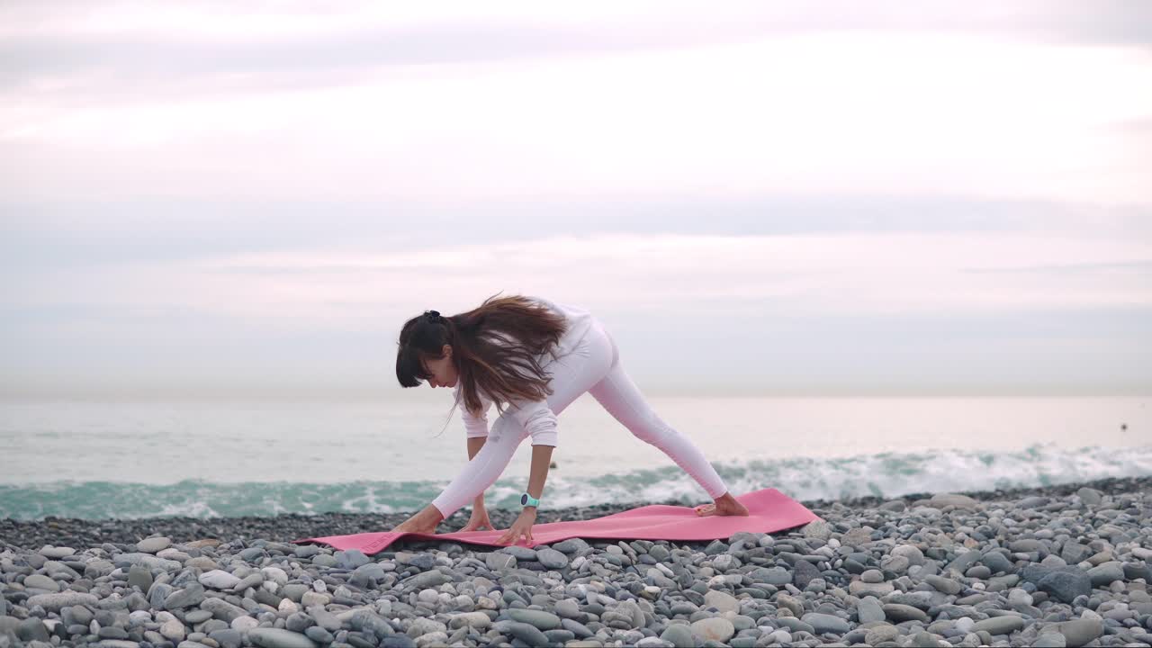 mujer practicando yoga en la playa