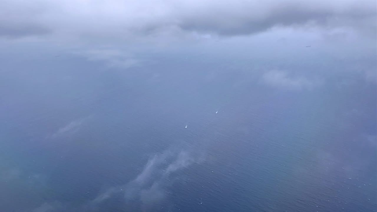 구름이 가득한 하늘 아래의 조용한 바다, 구름을 통해 어보는 빛의 암시, 공중 전망