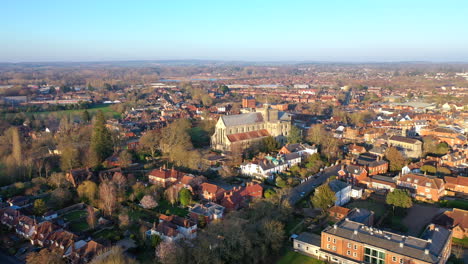 Aerial-rising-over-Romsey-UK-market-town-and-Romsey-Abbey-during-sunrise-4K