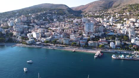 Toma-Aérea-Lenta-Que-Se-Acerca-A-Sarande,-Albania-Junto-Al-Hermoso-Mar-Mediterráneo