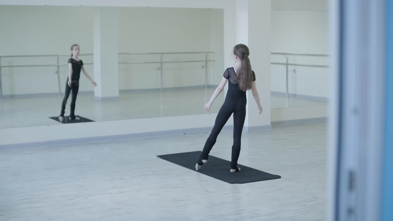 Giovane ballerina a lezione in studio. Esercizio di allenamento. Posa di stretching. Ballerina che pratica la tecnica dell'equilibrio. Eleganza classica e fitness