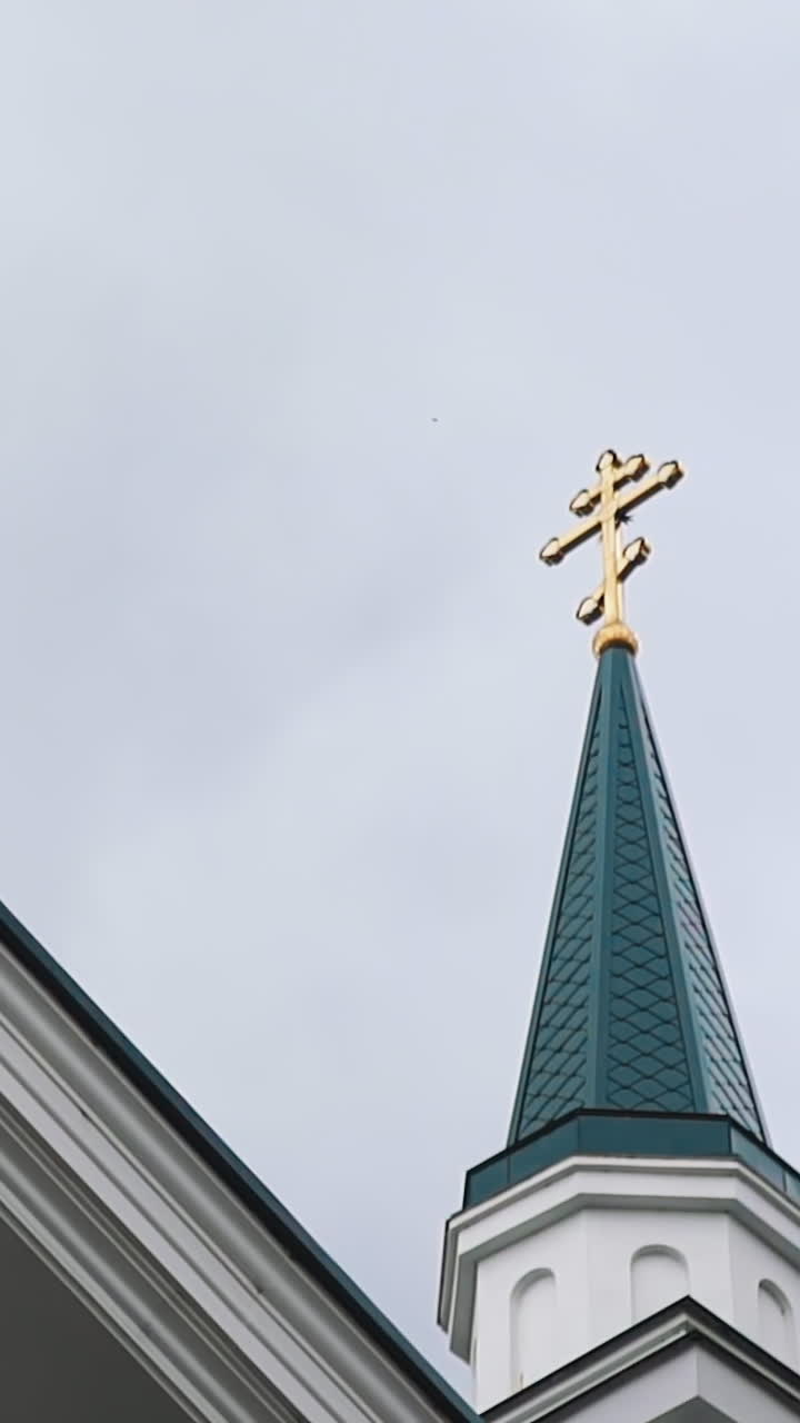 Christian orthodox church building with crosses on green roofs under cloudy sky low angle shot. Religious community place for meetings. Culture heritage
