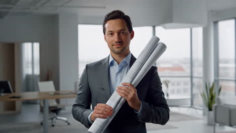 architect holding blueprints in office