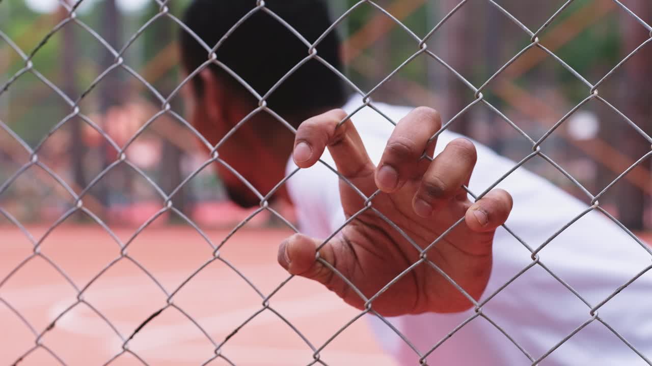 Black young man plays basketball on a red outdoor court