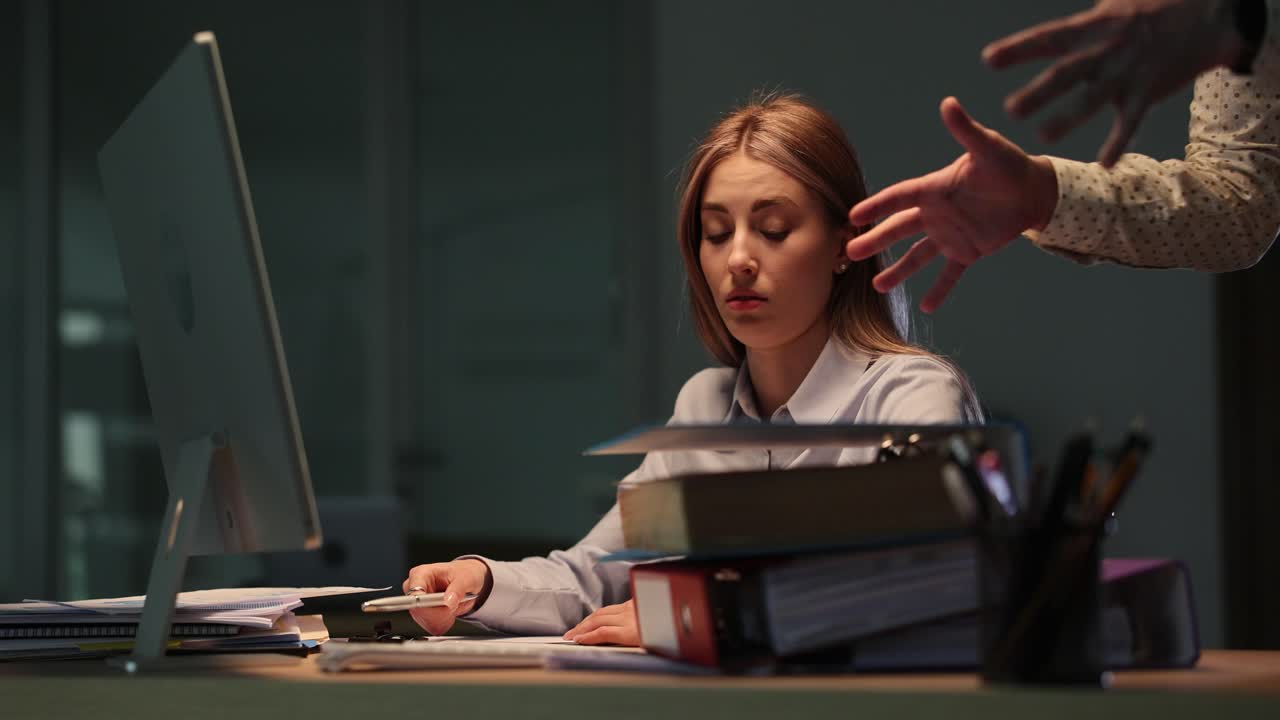 Stressed businesswoman overwhelmed with paperwork at her office desk