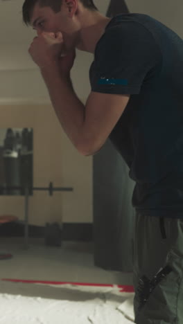 los niños miran al entrenador mostrando el bloque en el gimnasio. los estudiantes junior divertidos aprenden la técnica de lucha del instructor en el club deportivo en cámara lenta. el equipo de niños en la lección de autodefensa