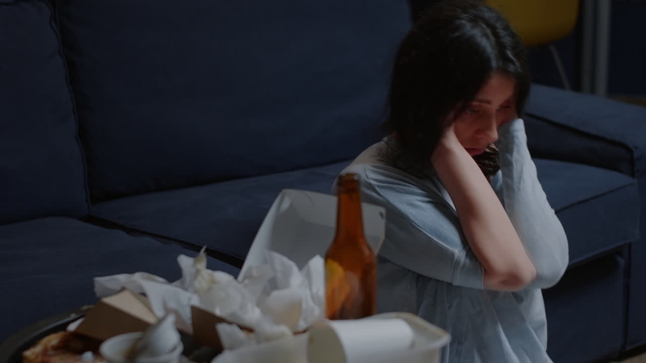 Desperate woman sitting alone on floor swaying having suicide thoughts