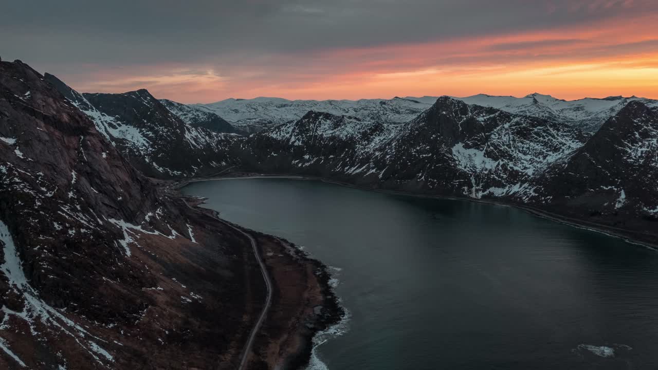 Maestoso paesaggio di fiordi a Senja, Norvegia, con montagne innevate al tramonto.