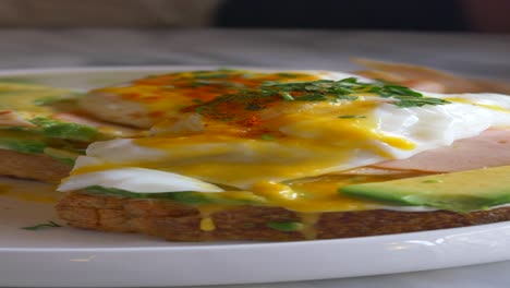 primer plano de tostadas de aguacate con huevos cocidos y salsa holandesa