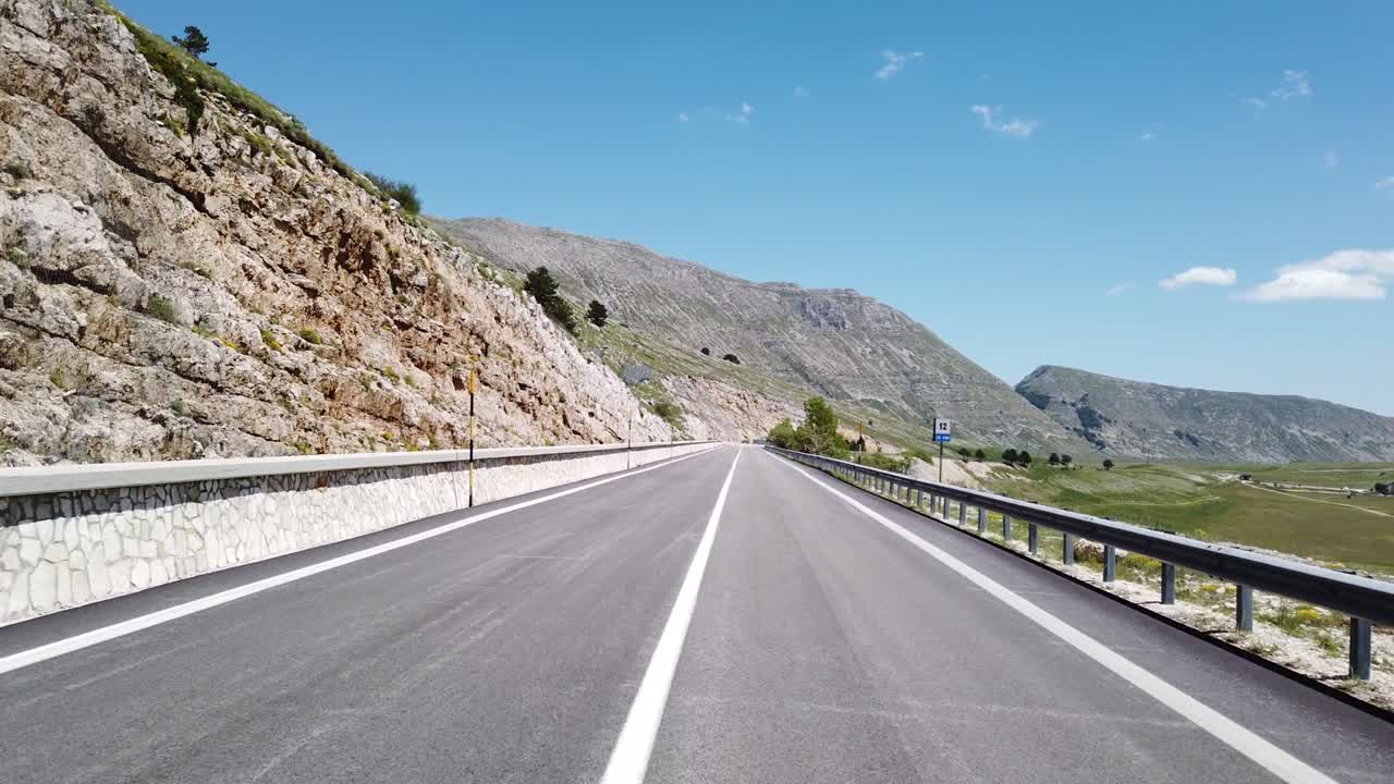 Veduta in movimento (auto, moto o bicicletta) di un paesaggio montano