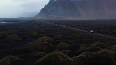 4K-Drohnenvideo-Eines-Autos,-Das-Durch-Die-Abgelegene-Landschaft-Islands-Fährt