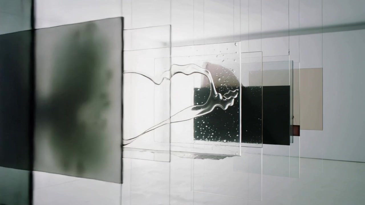 Telecamera panoramica che mostra pannelli colorati scorrere a destra in galleria, rivelando una scia viscosa e bolle