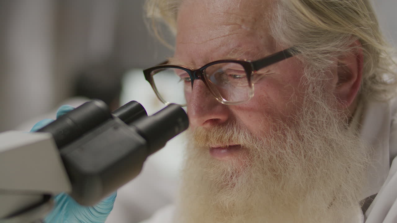 Elderly Archaeologist Using Microscope for Research in Laboratory