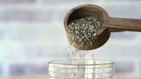 chia seeds pouring into a glass of water