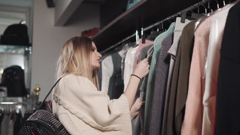 young woman is examining prices in clothing store on a sale