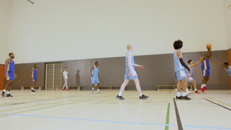 basketball players practicing in gym, shooting hoops and improving skills