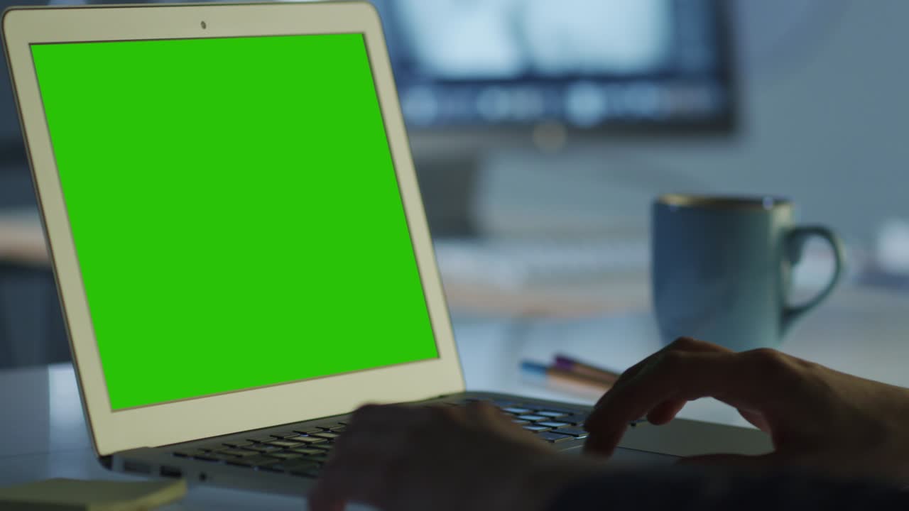 el programador está trabajando en la oficina en una computadora portátil con pantalla verde para el modelo