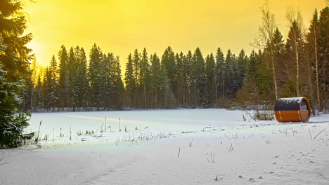 Time-lapse-shot-of-beautiful-snowy-forest-scenery-with-wooden-sauna-during-sunrise-in-background