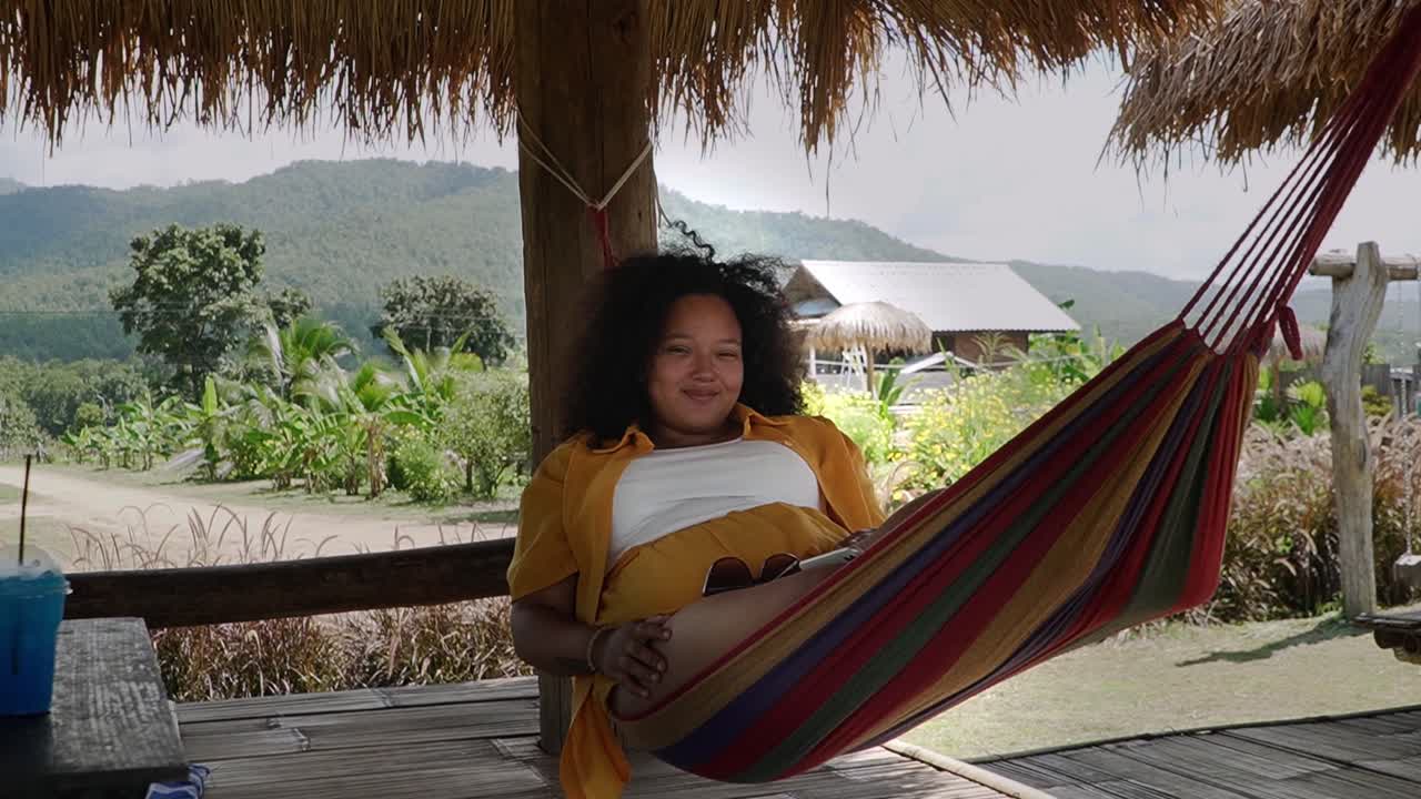 hermosa chica negra disfrutando de su tiempo en una hamaca