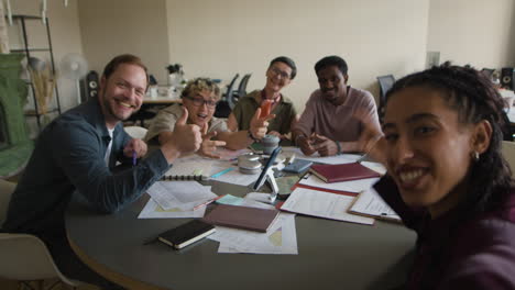diverse team smiling and posing for a group photo in an office meeting