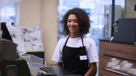 Portrait-of-and-african-american-worker-at-grocery-store-checkout,-friendly-smiling