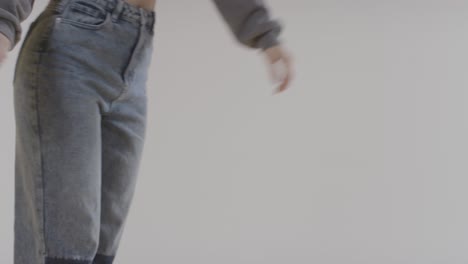 Close-Up-On-Legs-And-Feet-Of-Woman-Having-Fun-Dancing-Against-White-Studio-Background