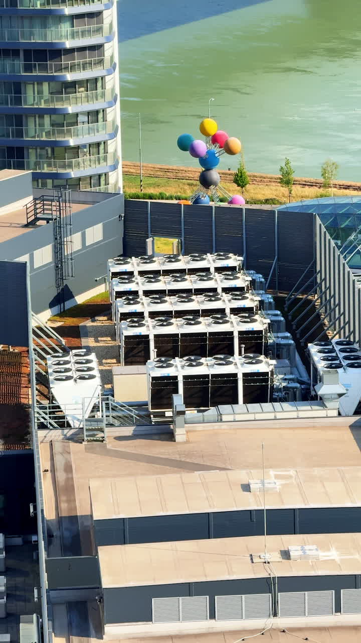 Rooftop units and balloons. Rooftop with cooling units shows colorful balloons floating above, providing a lively contrast against the background