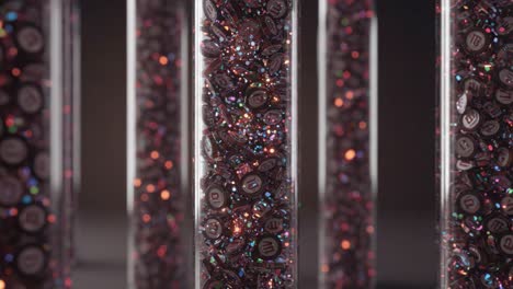 close-up of colorful candy coating: a stunning display of glossy chocolate confections in transparent vessels capturing light and sparkle