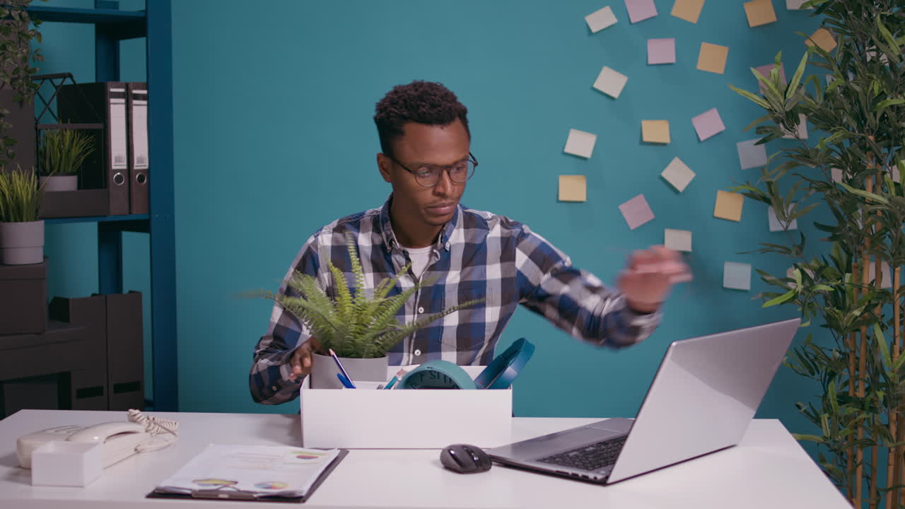 Frustrated person packing up belongings in box after getting fired