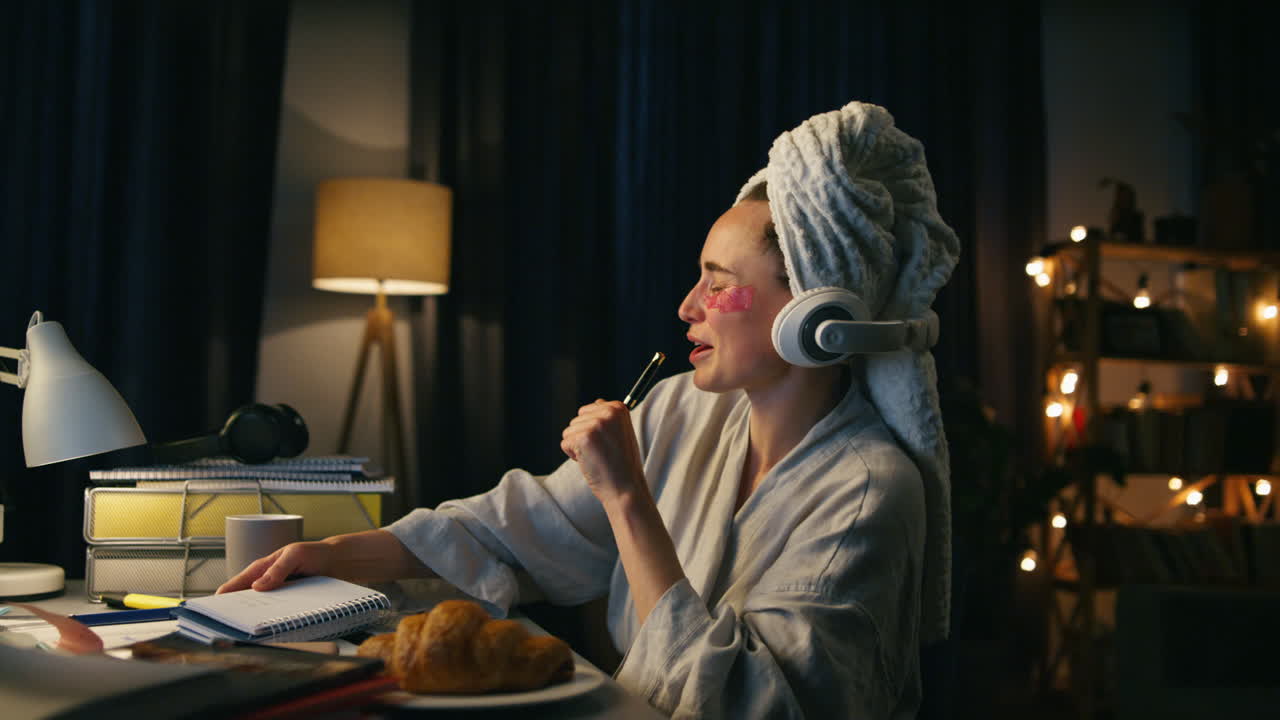 mujer positiva cantando bailando en el hogar en el lugar de trabajo en primer plano. mujer sonriente tomando notas